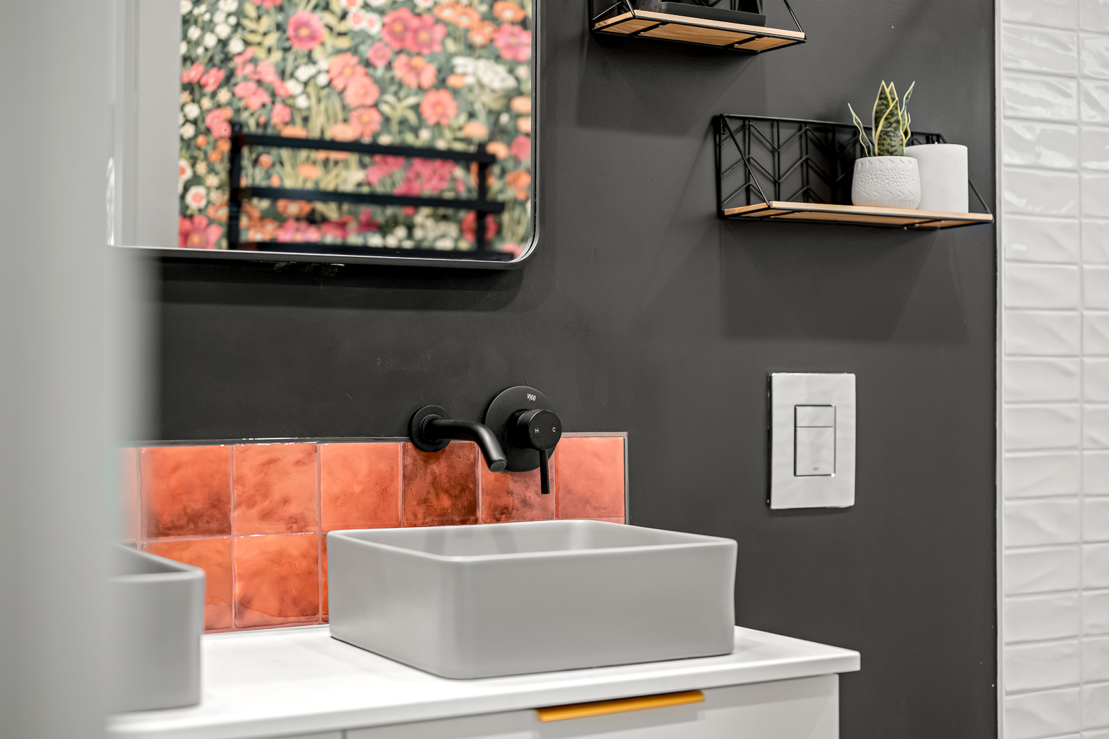 Bathroom detail — vessel sink, copper tile, and dark charcoal wall